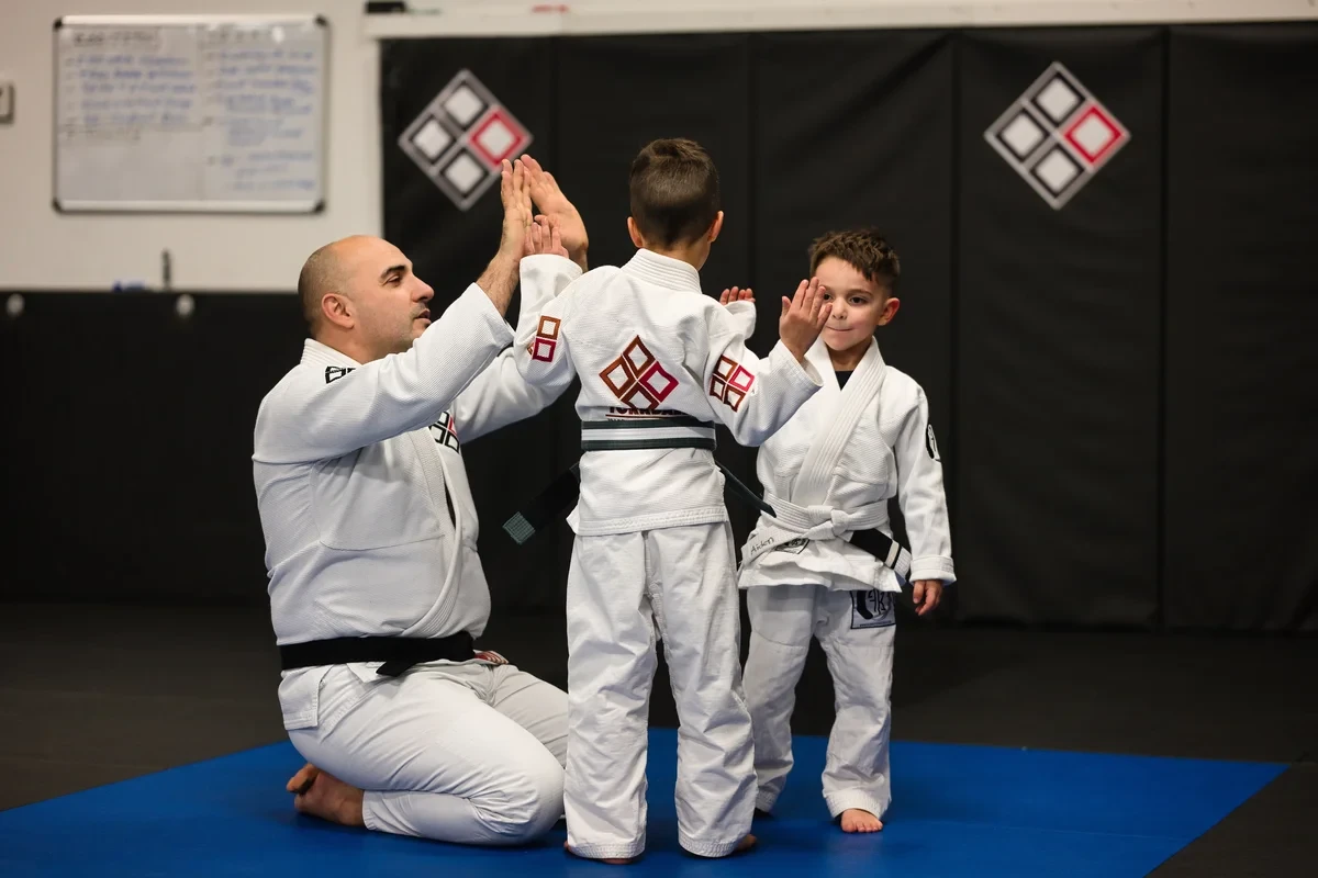Kids BJJ instructor celebrating with Toronto area students - positive reinforcement training